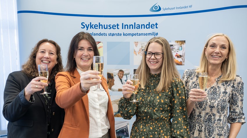 4 smilende kvinner løfter glass med sprudlende Mozell